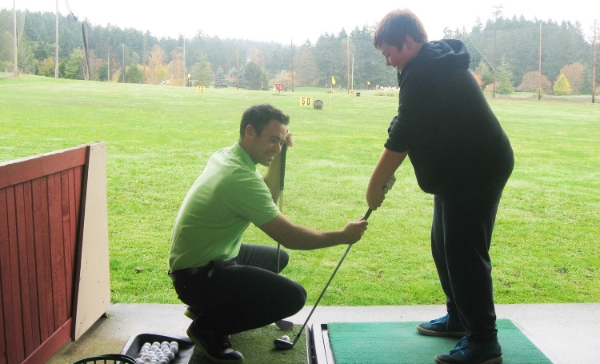 instructor working with student on his swing