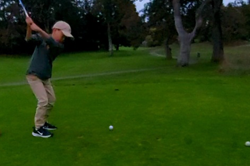 young golfer taking swing